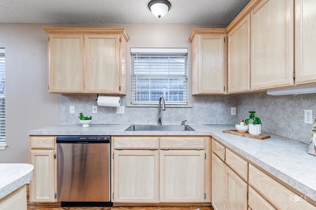 kitchen featuring sink, tasteful backsplash, a textured ceiling, light brown cabinets, and stainless steel dishwasher