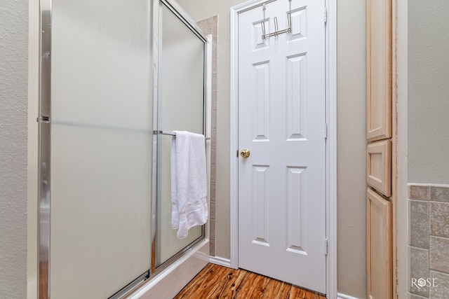 bathroom featuring walk in shower and hardwood / wood-style floors