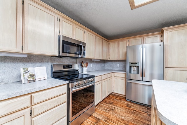 kitchen featuring appliances with stainless steel finishes, light brown cabinets, and light hardwood / wood-style floors