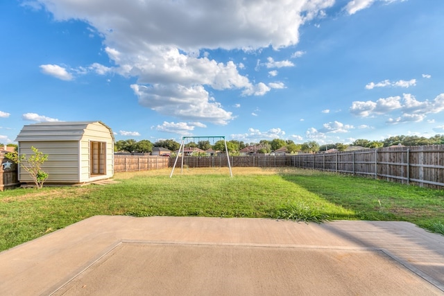 view of yard featuring a storage shed, a patio, and a playground