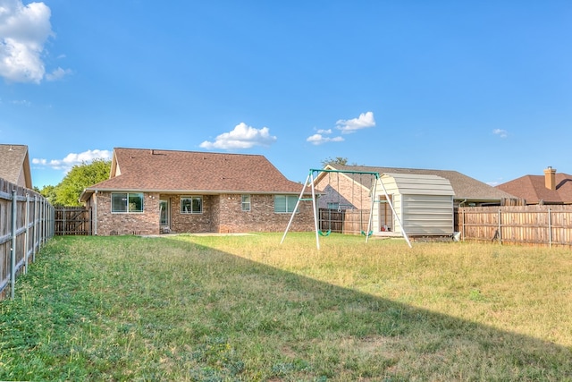 rear view of house with a playground and a yard