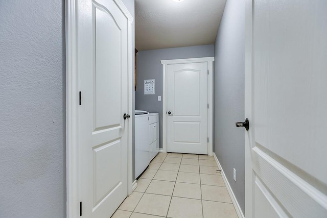 interior space featuring washing machine and dryer and light tile patterned floors