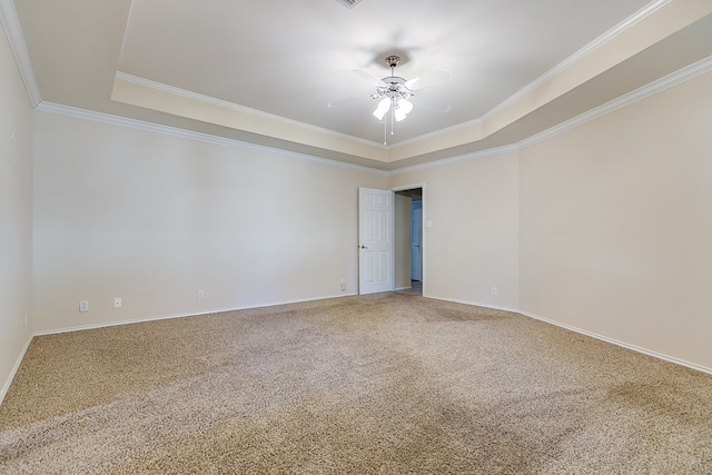 carpeted spare room with ornamental molding, ceiling fan, and a tray ceiling