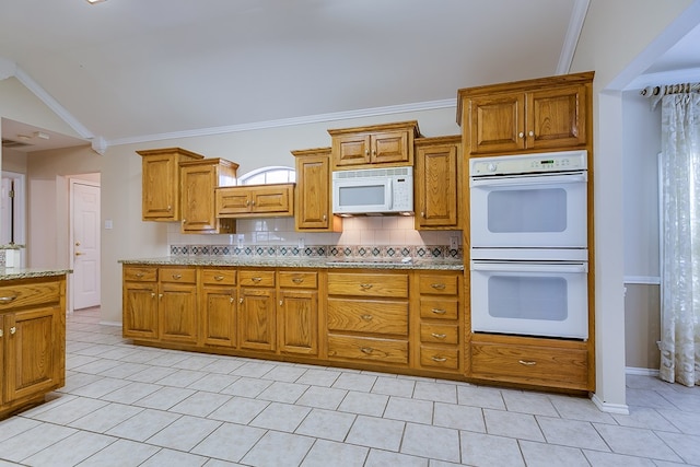 kitchen with vaulted ceiling, backsplash, ornamental molding, light stone counters, and white appliances