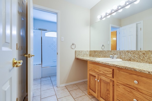 bathroom featuring tile patterned flooring, vanity, and bath / shower combo with glass door