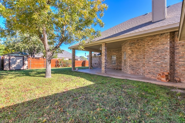 view of yard with a storage shed and a patio area