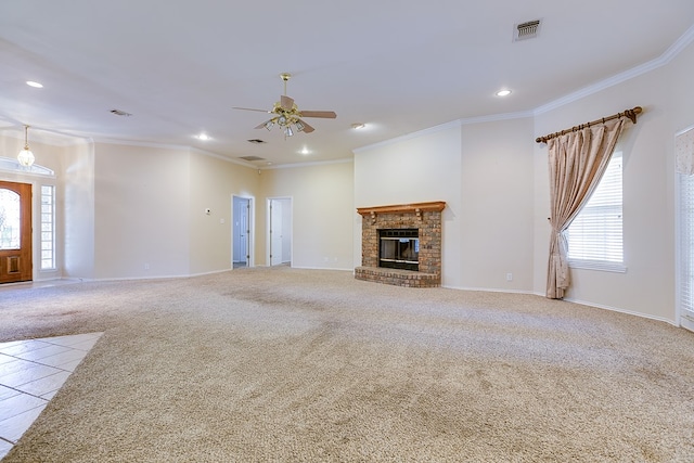 unfurnished living room featuring ceiling fan, ornamental molding, a brick fireplace, and light carpet