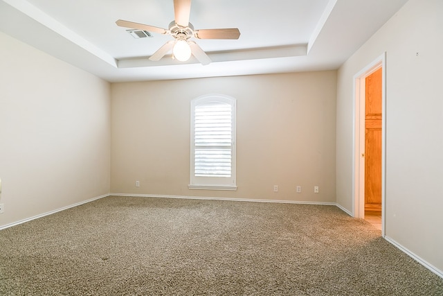 carpeted empty room featuring ceiling fan and a tray ceiling