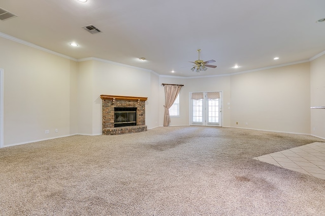 unfurnished living room with ceiling fan, ornamental molding, a fireplace, and carpet