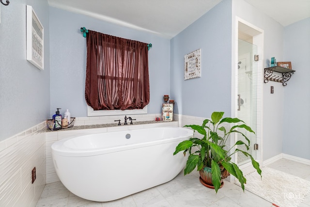 bathroom featuring tile walls and a shower with shower door