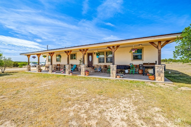 rear view of house with a patio area and a lawn