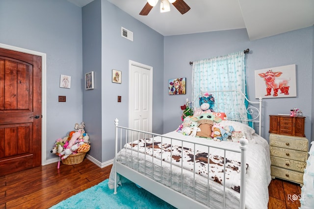 bedroom with ceiling fan, dark hardwood / wood-style floors, vaulted ceiling, and a closet