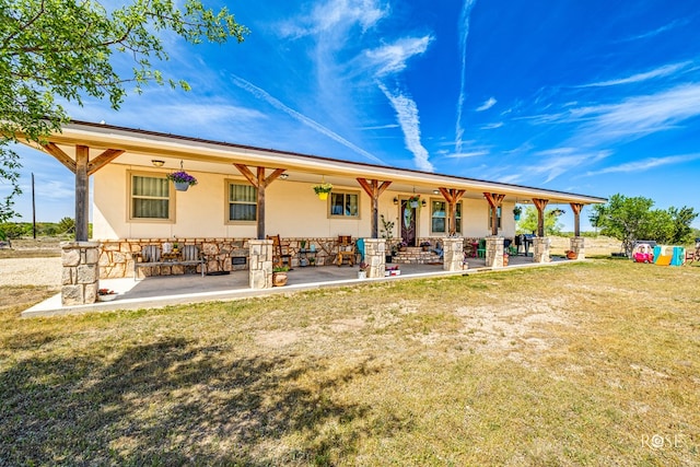 rear view of property with a yard and a patio area