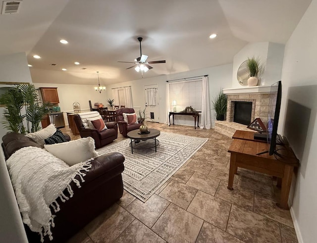 living room with ceiling fan with notable chandelier and vaulted ceiling