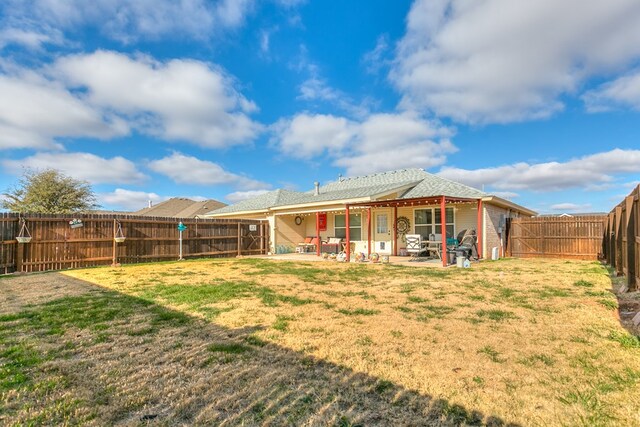 back of house with a lawn and a patio area