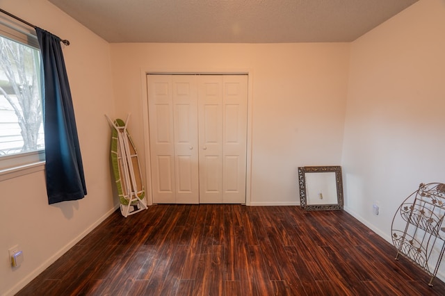 unfurnished bedroom featuring dark hardwood / wood-style flooring and a closet