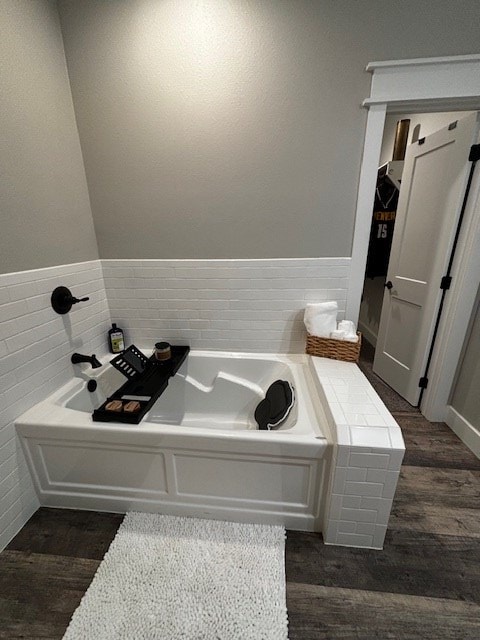 110 Vick Dr, Brownwood, TX 76801 - bathroom featuring wood-type flooring, tile walls, and a bathtub