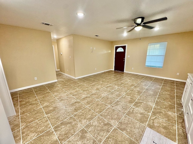 interior space with ceiling fan, tile patterned floors, and a textured ceiling