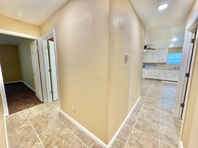 hallway with light tile patterned floors and sink