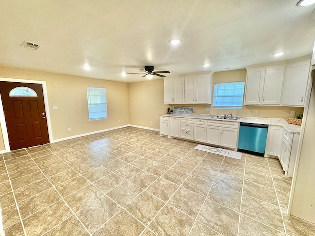 kitchen with dishwasher, plenty of natural light, sink, and white cabinets