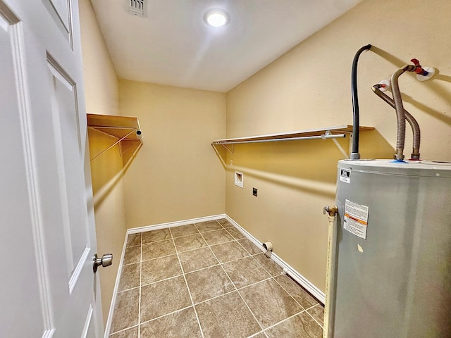 laundry room featuring tile patterned floors and water heater