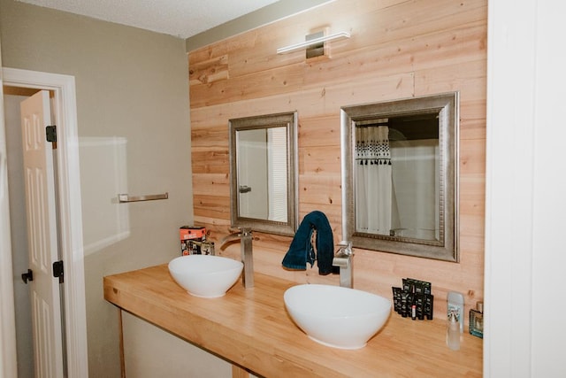 bathroom featuring vanity and wood walls