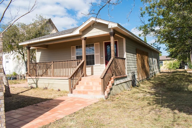 bungalow with a porch and a front lawn