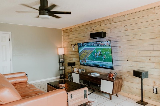 living room with light tile patterned flooring, ceiling fan, and wood walls