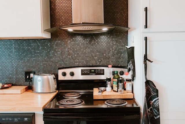 kitchen with electric range oven, wall chimney range hood, white cabinets, and decorative backsplash