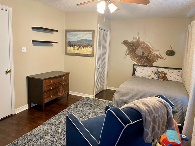 bedroom with dark hardwood / wood-style flooring, a textured ceiling, ceiling fan, and a closet