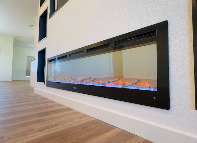 room details featuring a multi sided fireplace and wood-type flooring