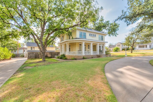 view of front of home with a porch and a front yard