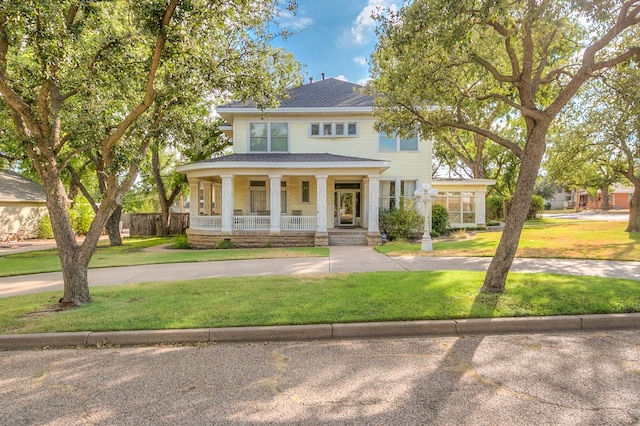 view of front facade featuring covered porch and a front yard