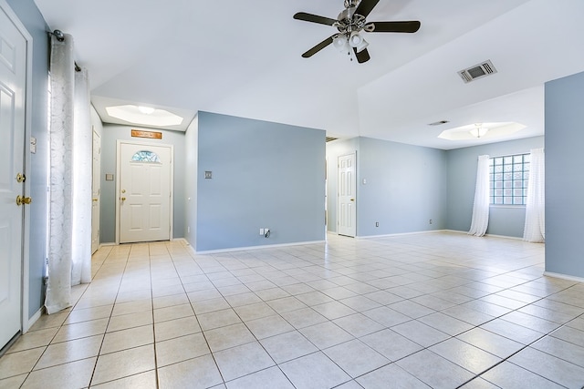 empty room featuring light tile patterned floors, visible vents, baseboards, and ceiling fan