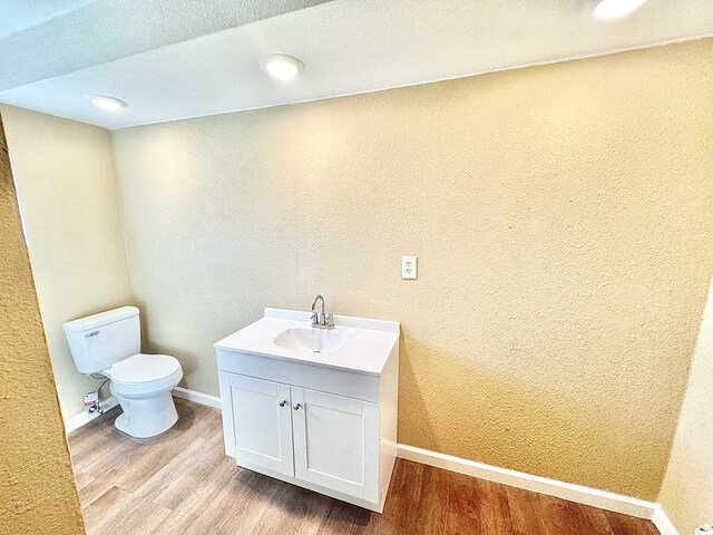 bathroom with vanity, wood-type flooring, and toilet