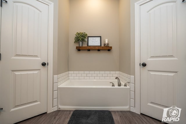 full bath featuring a bath and wood finished floors