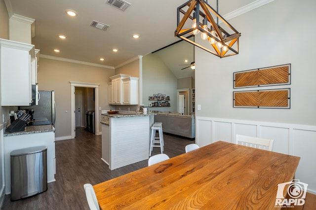 kitchen featuring dark wood-style flooring, crown molding, visible vents, white cabinets, and light stone countertops