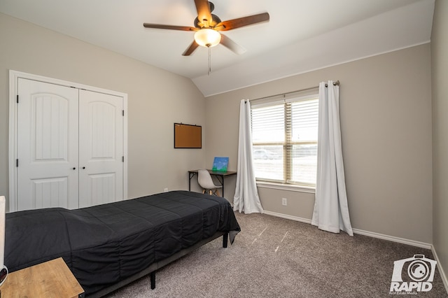 bedroom with lofted ceiling, a closet, a ceiling fan, carpet flooring, and baseboards