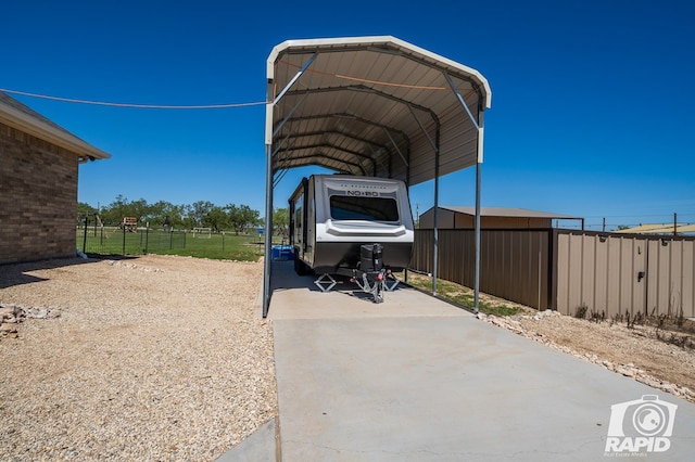 view of patio / terrace featuring a detached carport, fence, and driveway