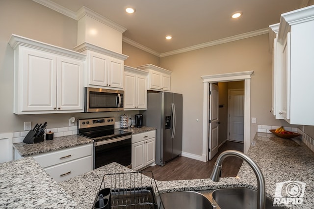 kitchen with white cabinetry, appliances with stainless steel finishes, dark wood finished floors, and ornamental molding