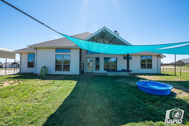 back of house featuring a lawn, a chimney, and fence