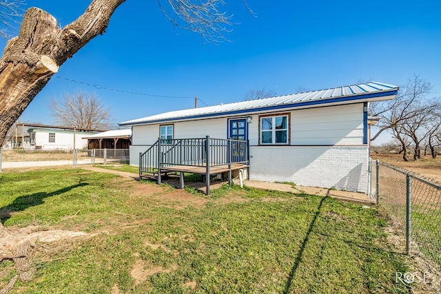 rear view of house with a lawn and a deck