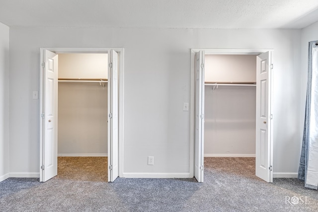 unfurnished bedroom featuring a walk in closet, carpet, and a textured ceiling