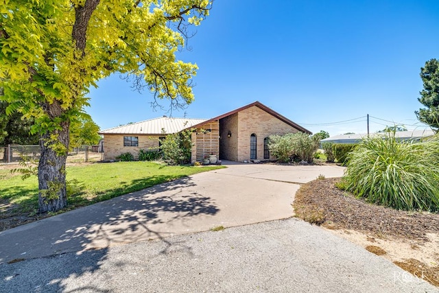 8126 N Fm 2288, San Angelo, TX 76901 - view of front of home featuring brick siding, concrete driveway, and metal roof