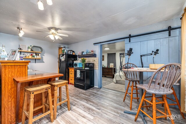8126 N Fm 2288, San Angelo, TX 76901 - dining area with a barn door, a dry bar, ceiling fan, and light wood finished floors