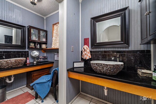 8126 N Fm 2288, San Angelo, TX 76901 - bathroom featuring crown molding, a sink, tile patterned flooring, backsplash, and a textured ceiling