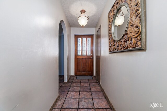 8126 N Fm 2288, San Angelo, TX 76901 - entryway featuring arched walkways, baseboards, a textured ceiling, and stone finish flooring