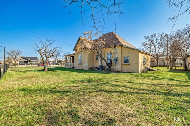 exterior space with central AC and a yard