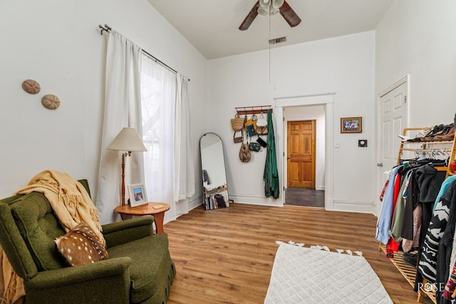 sitting room with wood-type flooring and ceiling fan