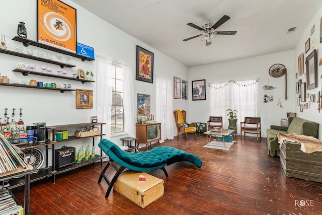 living area featuring dark wood-type flooring and ceiling fan